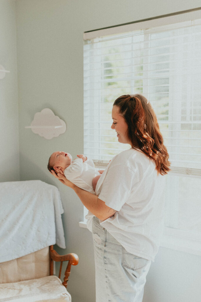 Photo of a mom holding her newborn baby in the baby's nursery taken in langley