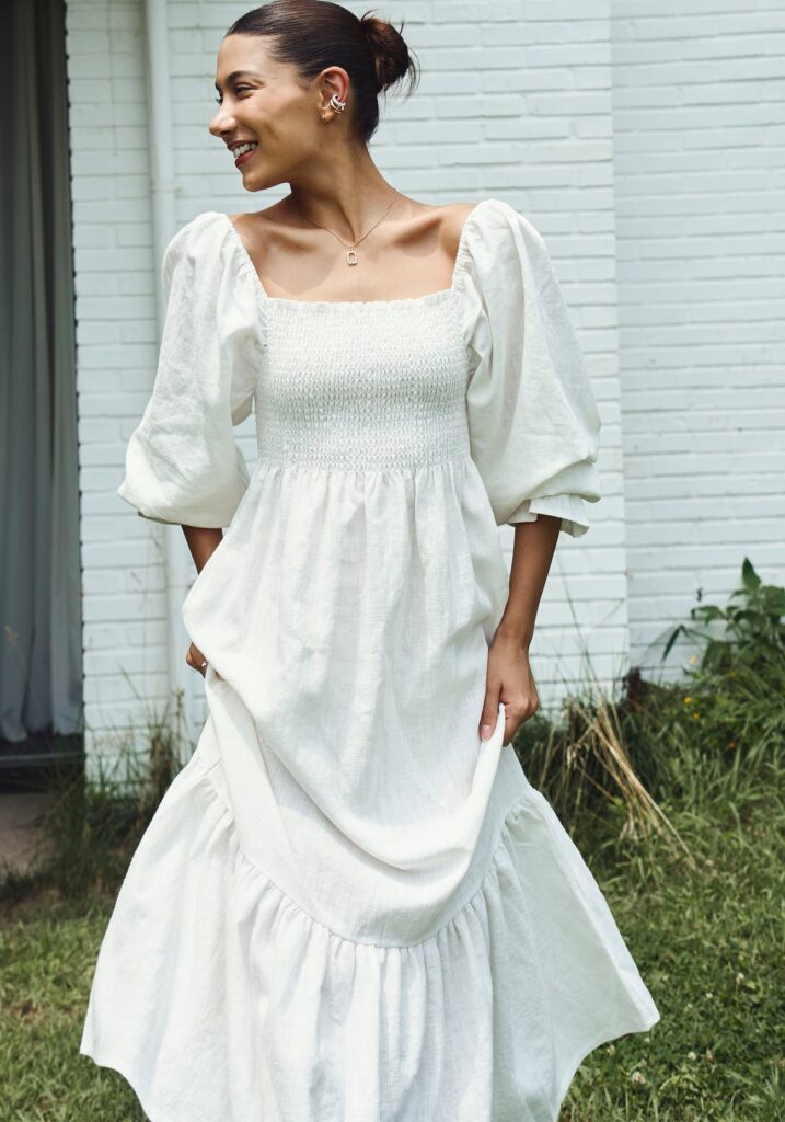 Photo of a women modelling a white long sleeve maternity photoshoot dress