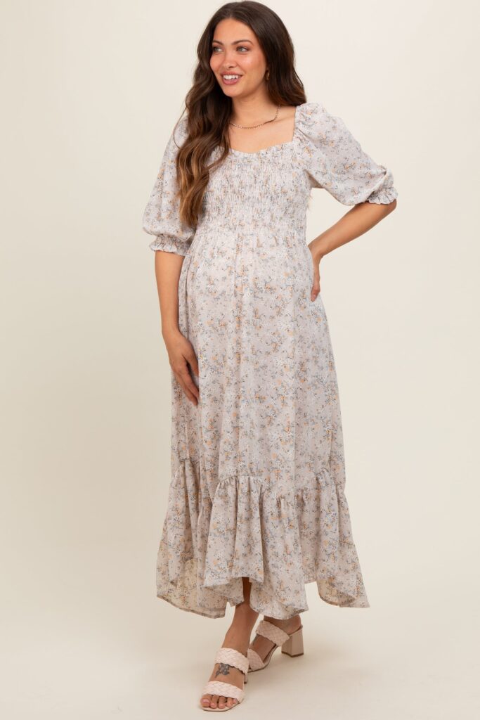 photo of a model wearing a quarter sleeve off white and floral patterned maternity photoshoot dress