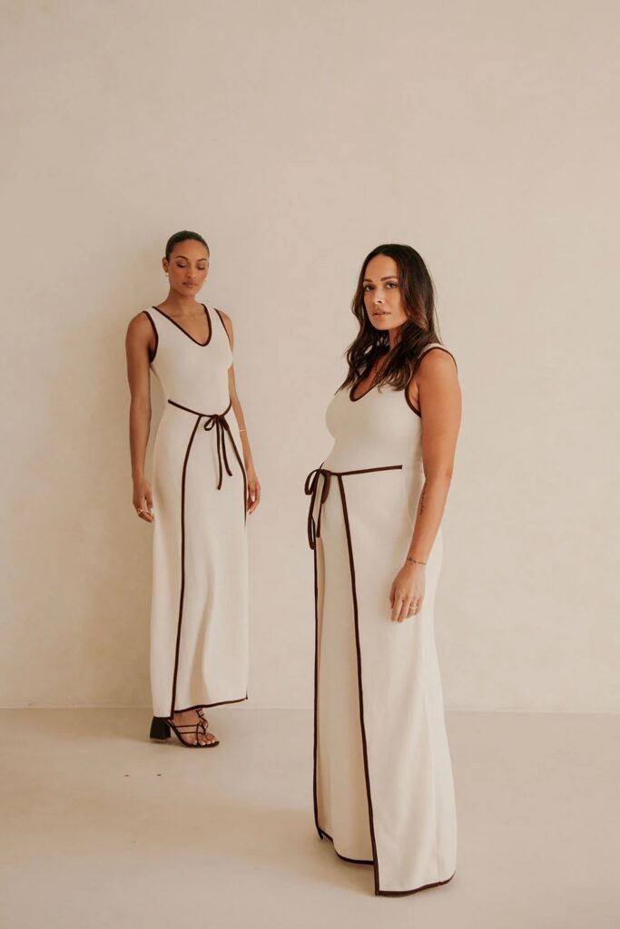 photo of 2 models wearing a white dress with a black tie around the belly