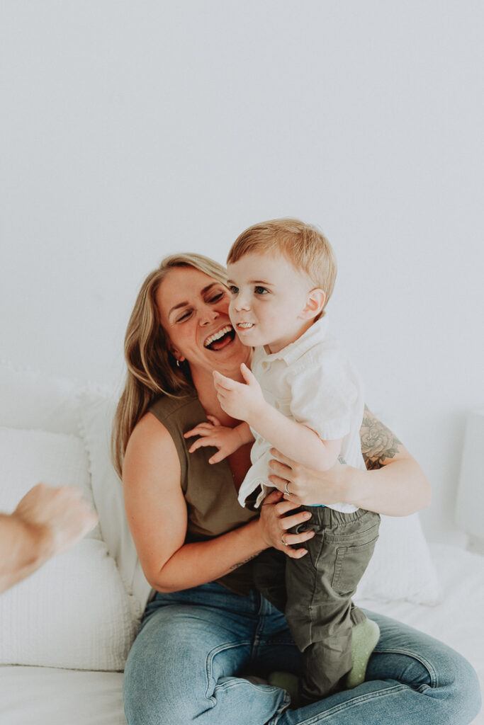 photo of a toddler and a mom where the toddler is eating a snack that dad has handed to him off screen taken in langley