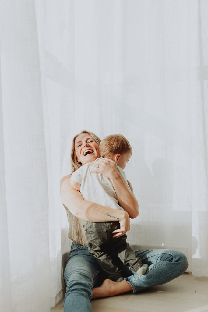 photo of a mom hugging her toddler son with a big smile on her face taken in langley