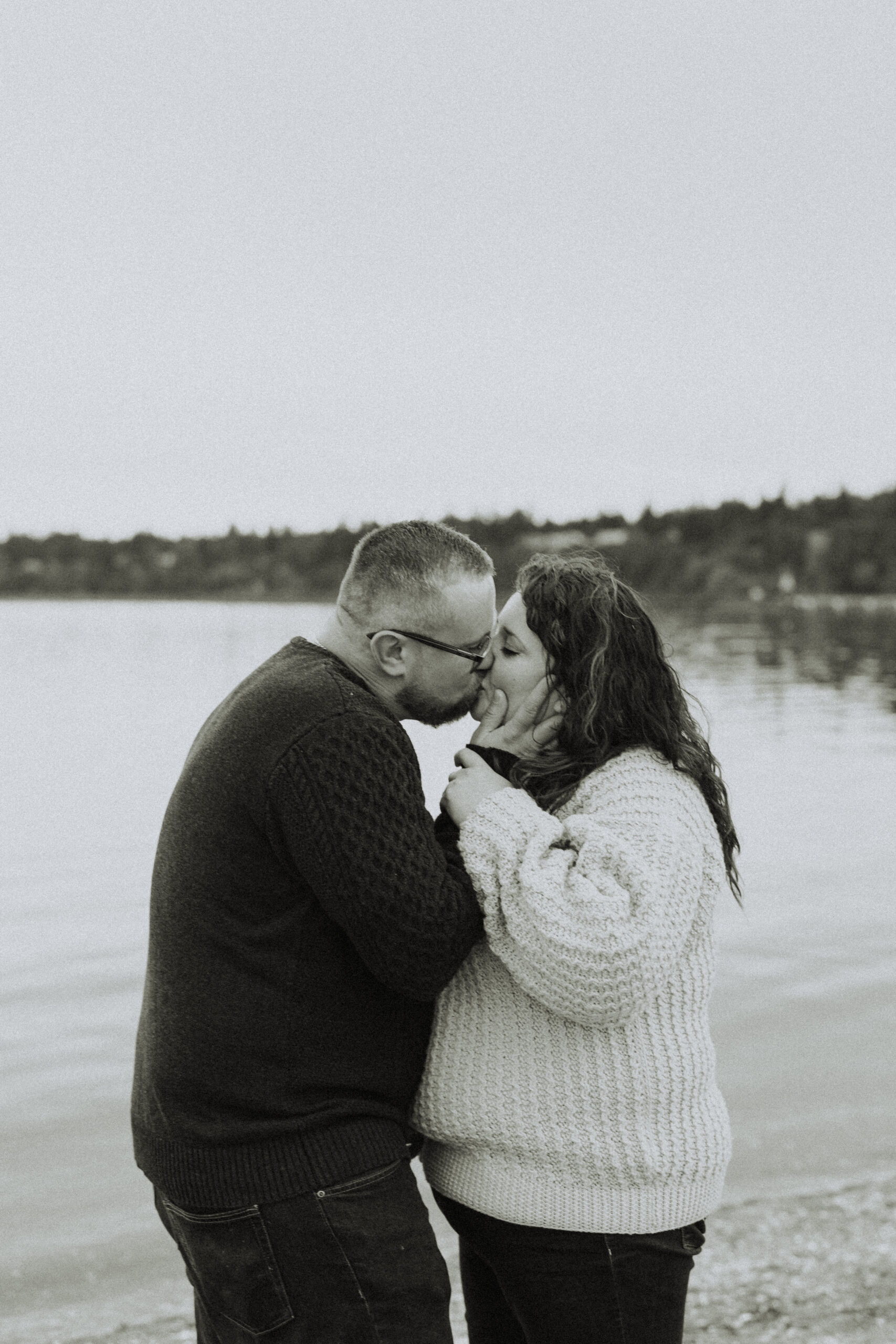 photo of a couple kissing with the ocean in the background taken in black and white posted for a Langley Restaurants date night blog 