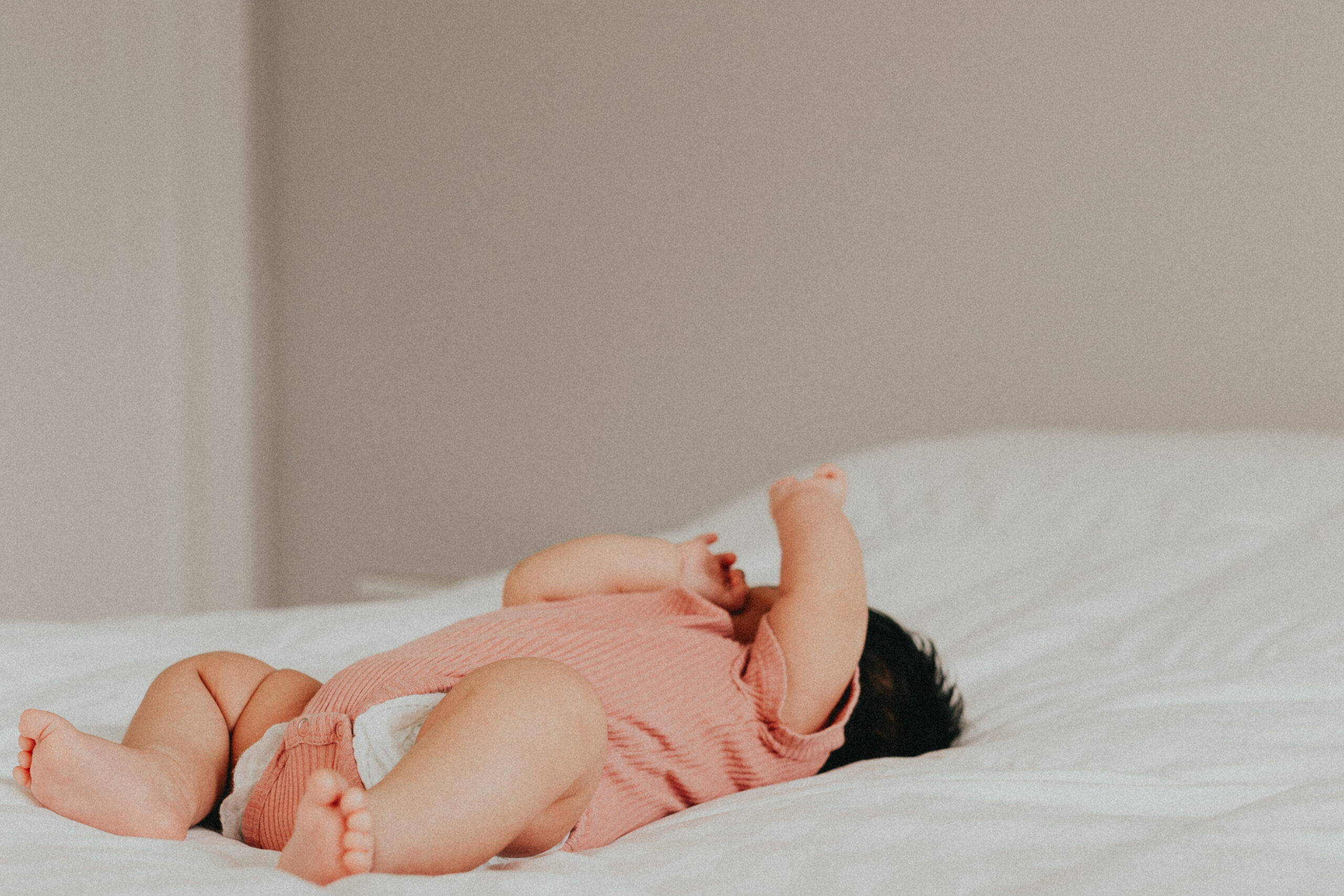 photo of a newborn baby laying on a bed with a white sheet taken by a langley newborn photographer