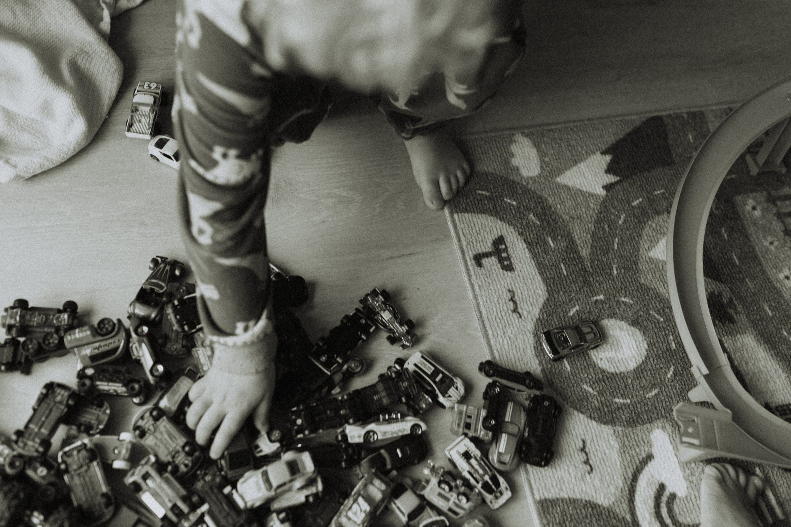 photo of a boy reaching for his cars while playing hot wheels as one of his indoor family activities