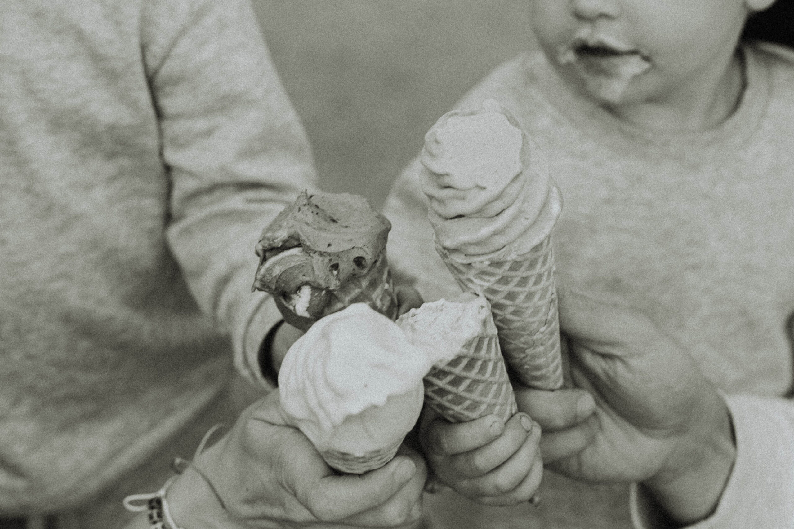 Black and white photo of a family oh 4 doing "cheers" with their ice cream cones