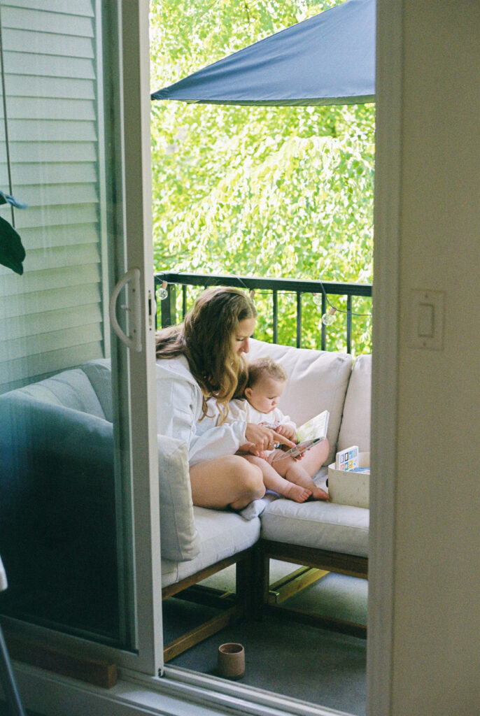 Photo of a mom and baby sitting together on their patio furniture 
