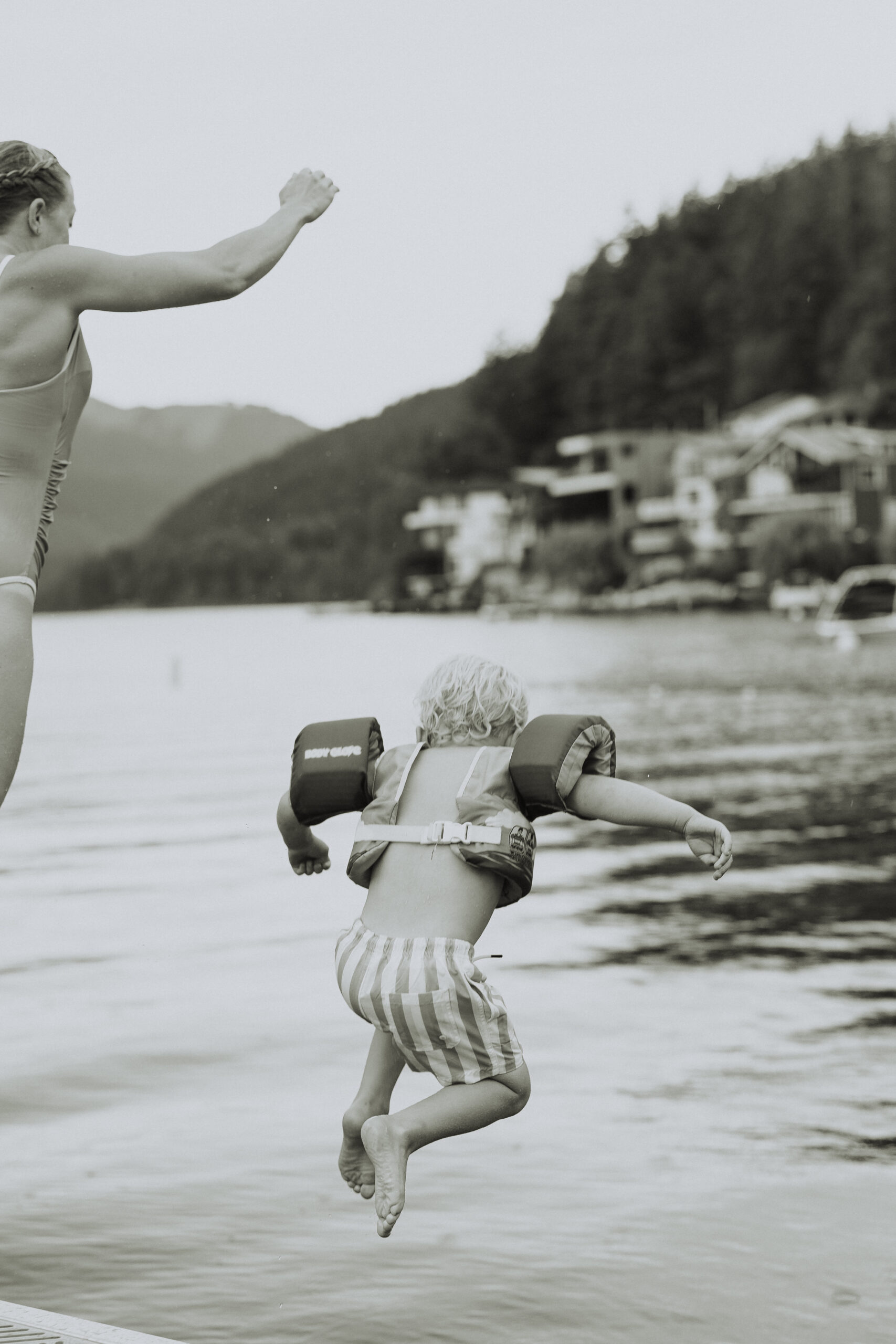 Black and white photo of a little boy jumping into a lake taken by a chilliwack photographer