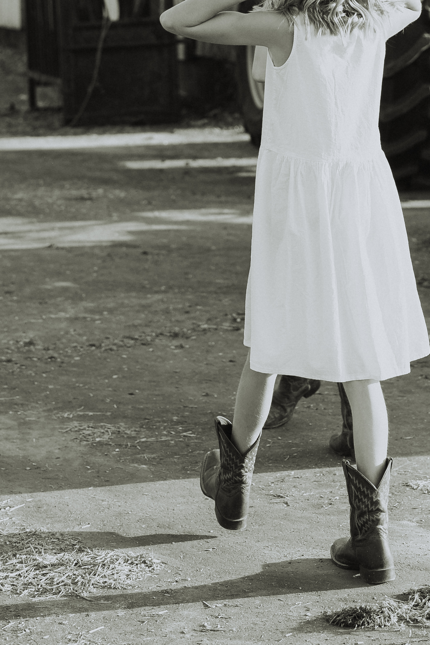 Photo of a girl wearing cowboy boots walking along the family farm for a blog about abbotsford pumpkin patches