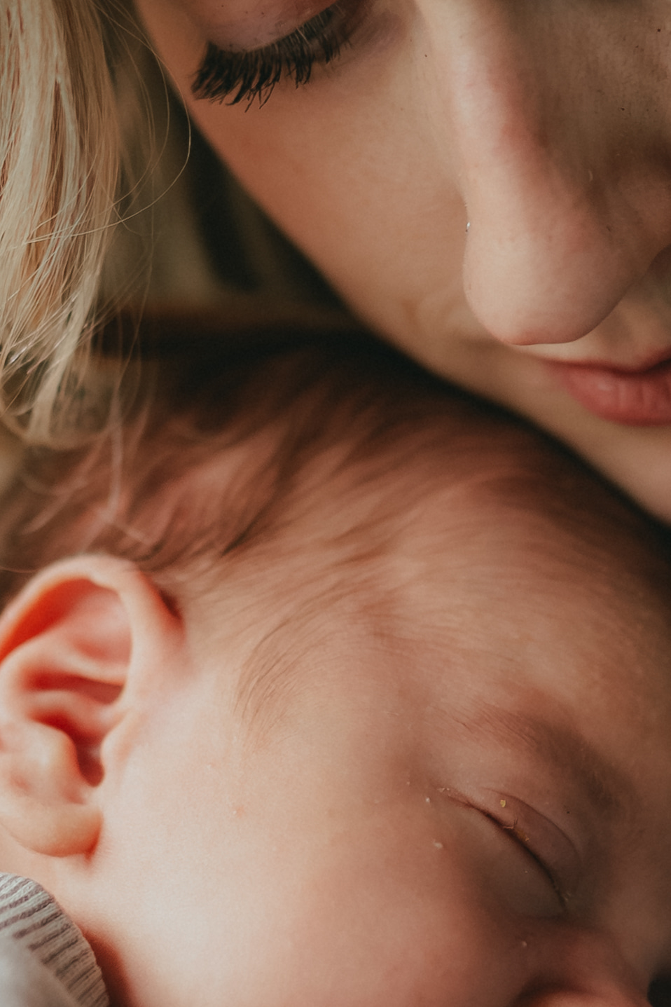 very close up photo of a mom snuggling her newborn son with her cheek resting on the baby's head. Taken by a newborn photographer, Abbotsford B.C.