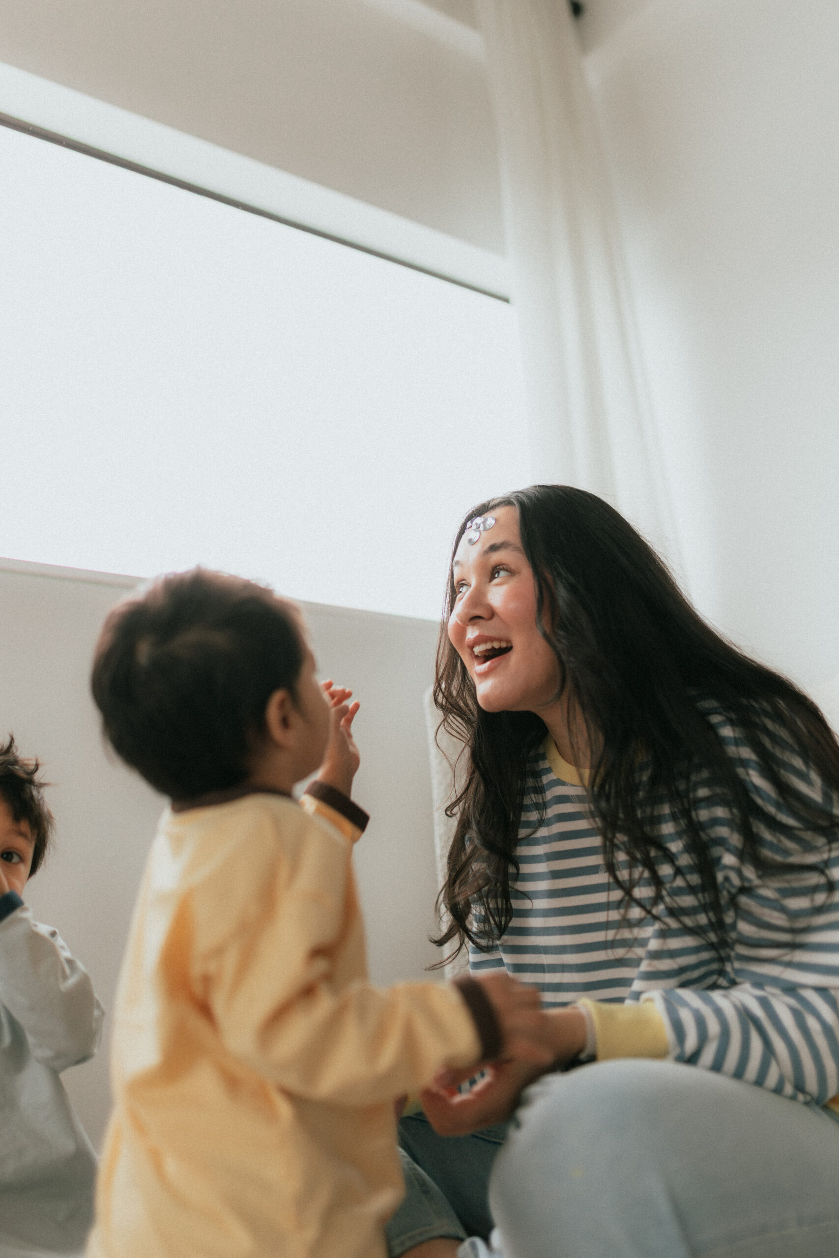 A young son is placing stickers on his moms face taken during a mother's day photoshoot