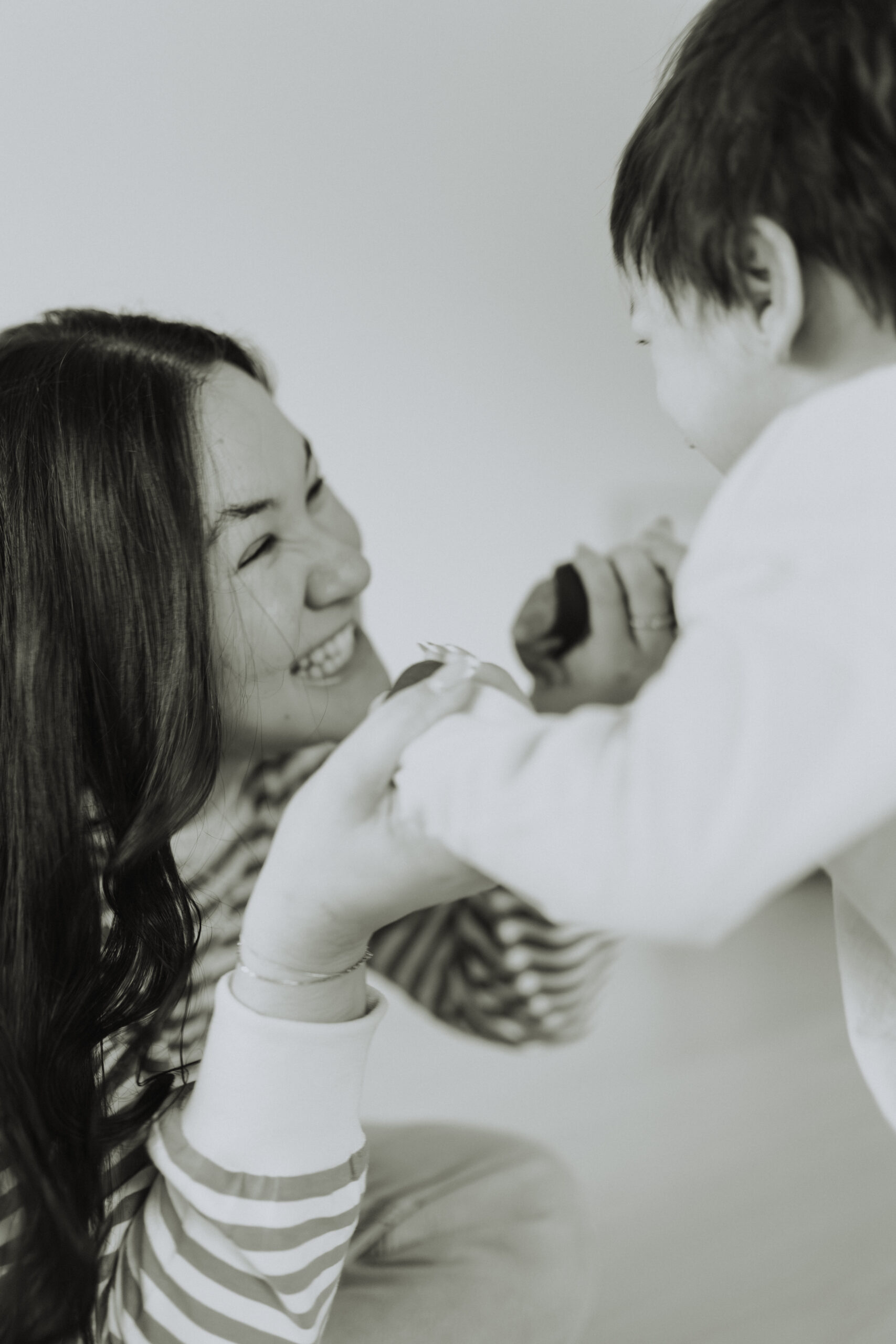 Black and white image of a mom playing with her young son for a motherhood photoshoot in abbotsford