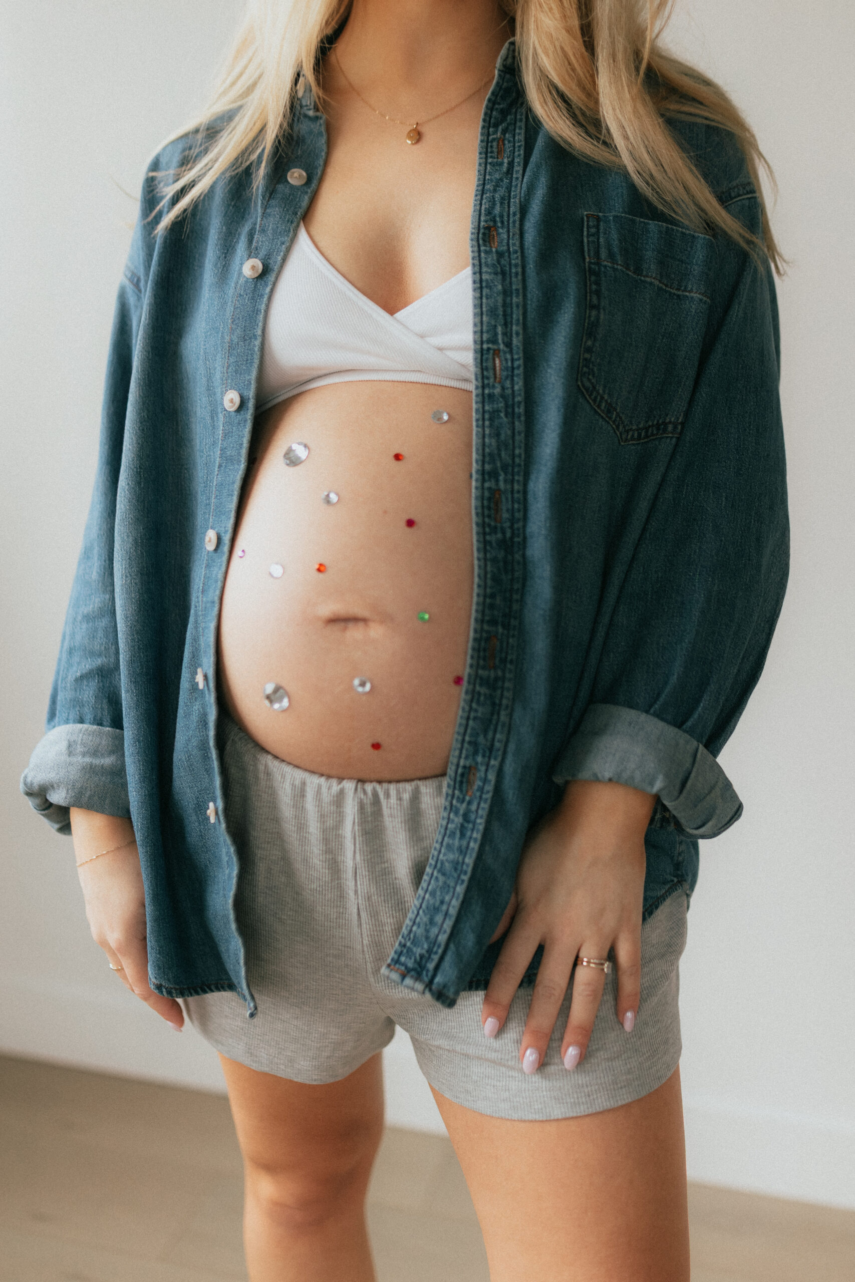 close up photo of a pregnant woman with her baby bump out and covered in gem stones taken by a maternity and newborn photographer abbotsford